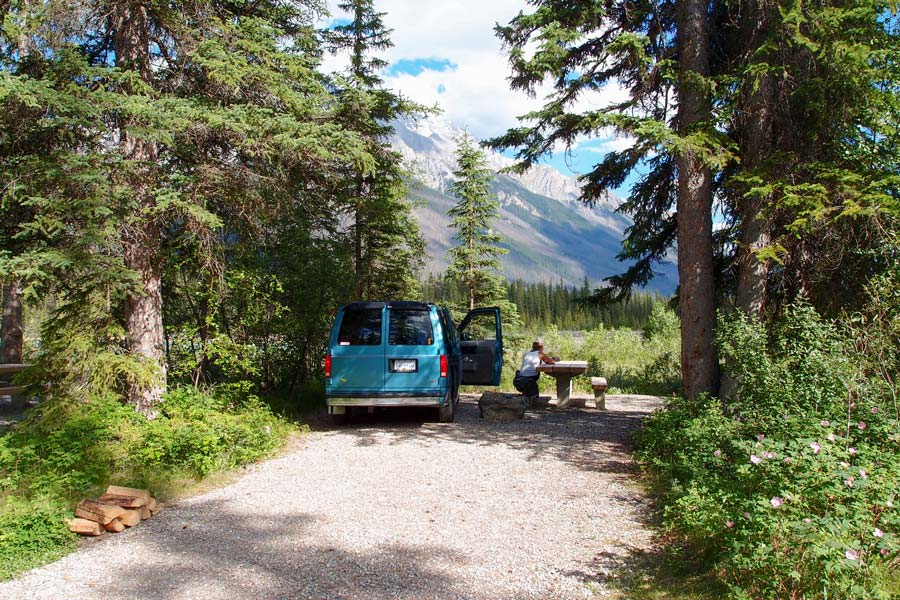 Meine Freundin Lena neben dem Auto auf Campingplatz mit Blick auf Rocky Mountains