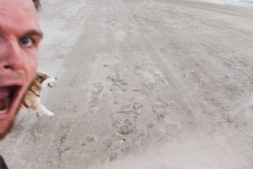 7 Tipps wie du deinen Hundealltag aufpeppst Ein Mensch und Hund haben sichtbar viel Spaß am Strand